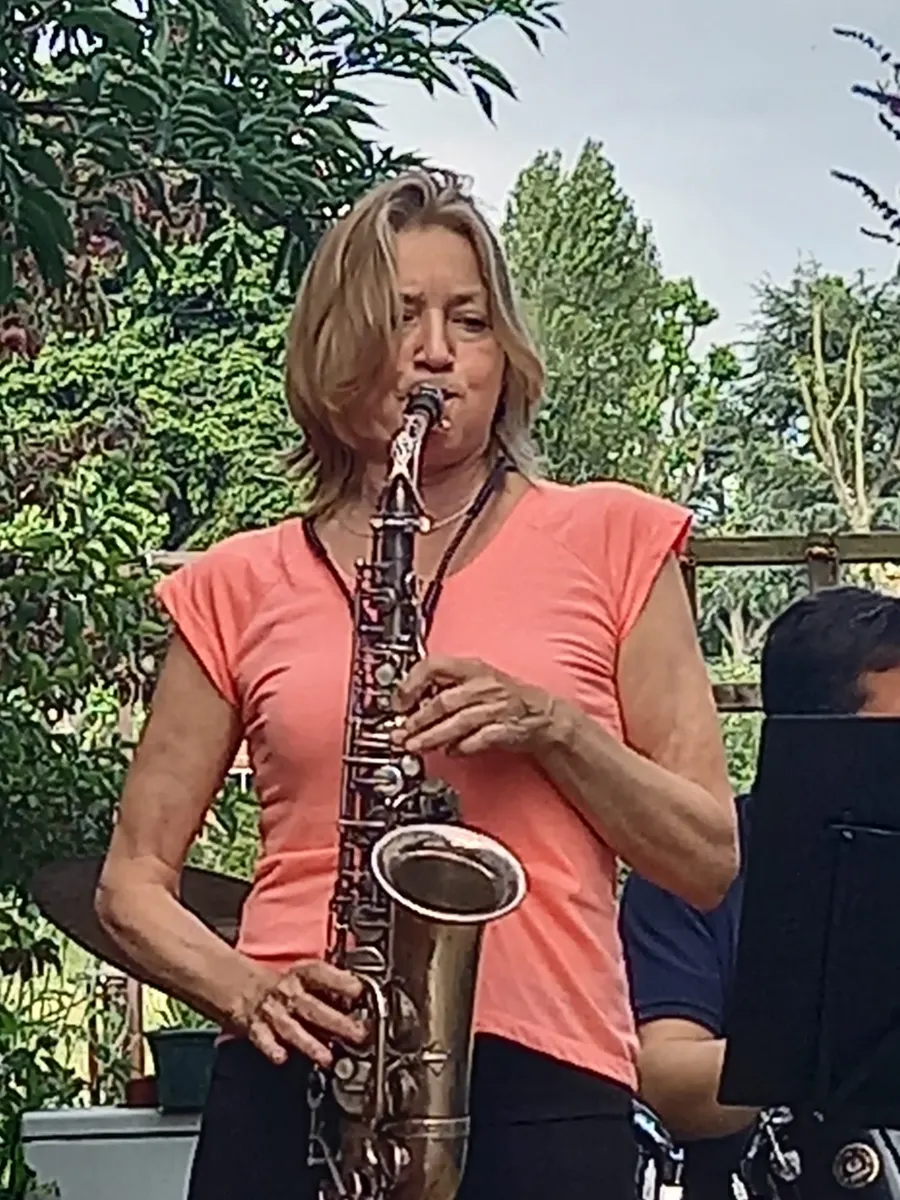 Saxofoniste speelt altsaxofoon in de tuin