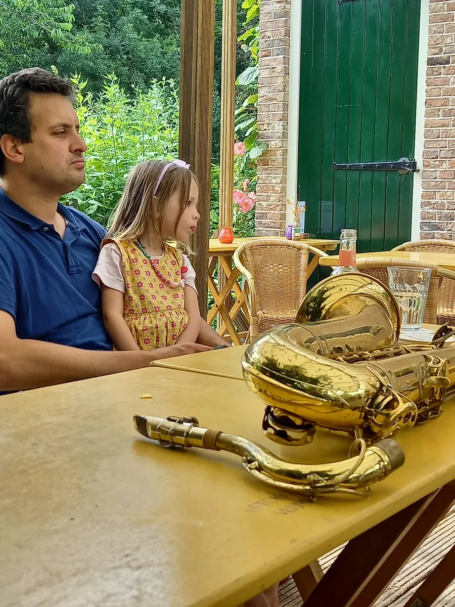 Saxofoons op tafel, publiek kijkt toe